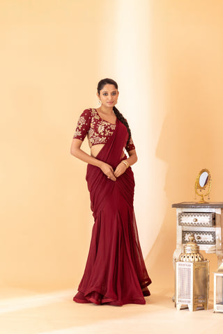 A maroon fish cut style saree with embroidered blouse