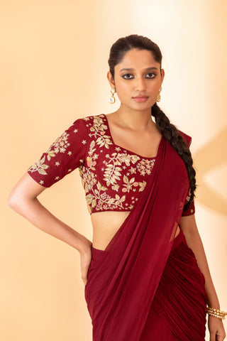 A maroon fish cut style saree with embroidered blouse