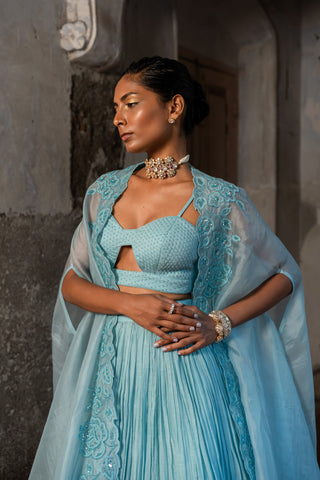 A pwder blue lehenga with maching blouse and cape