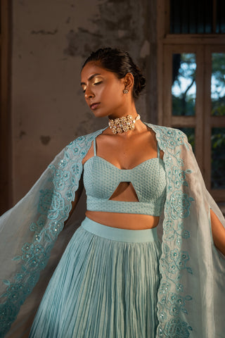 A pwder blue lehenga with maching blouse and cape