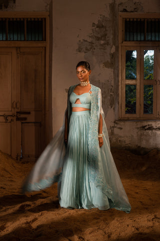 A pwder blue lehenga with maching blouse and cape